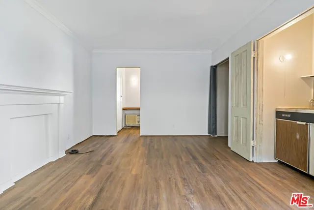 an empty room with wooden floor and entrance