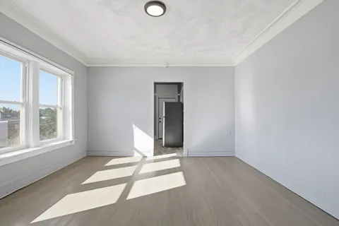 a view of a livingroom with wooden floor and a window