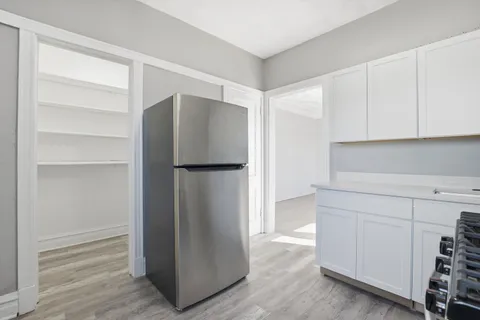 a kitchen with cabinets and a refrigerator
