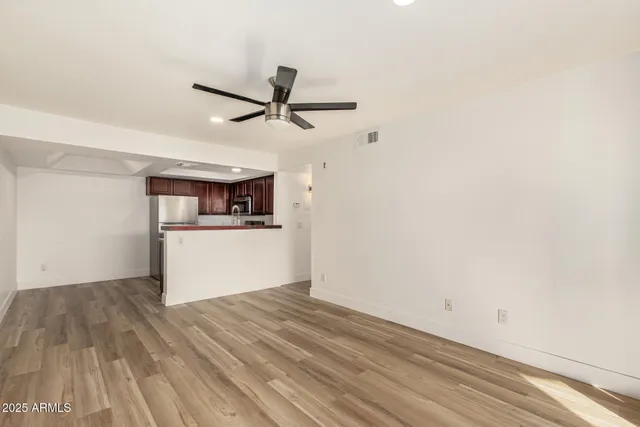 a view of a kitchen with wooden floor a ceiling fan and kitchen view