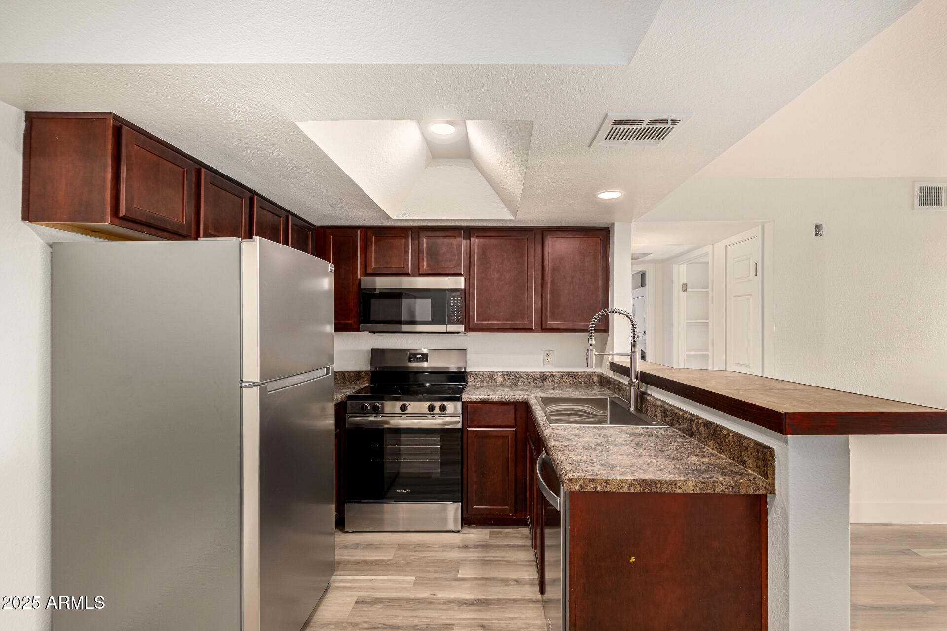 1720 East Thunderbird Road, Unit 2044 Phoenix, AZ 85022 - Photo 5 of 22 a kitchen with stainless steel appliances granite countertop a refrigerator a stove a sink and a microwave