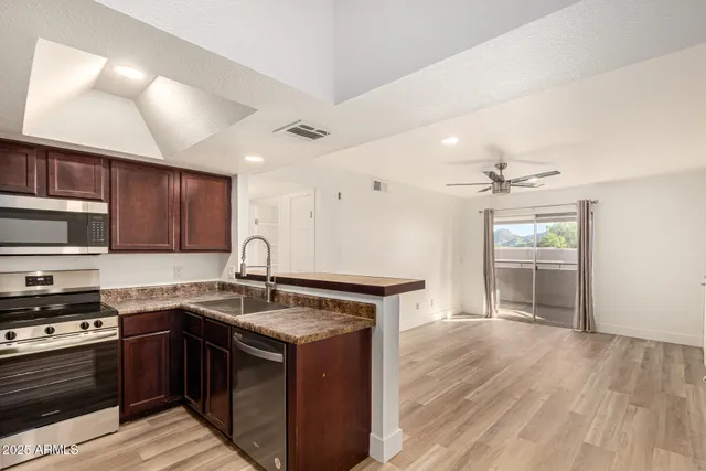 a kitchen with stainless steel appliances granite countertop a sink stove and cabinets