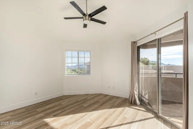 a view of a big room with wooden floor and windows
