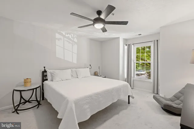 a bedroom with a bed and lamp on the dresser