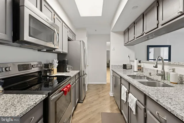 a kitchen with stainless steel appliances granite countertop a sink stove and cabinets