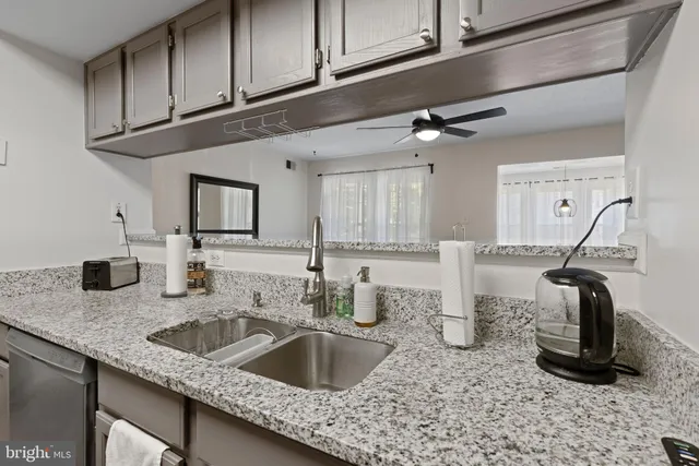 a kitchen with granite countertop a sink and cabinets