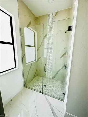 a bathroom with a glass shower door and a sink