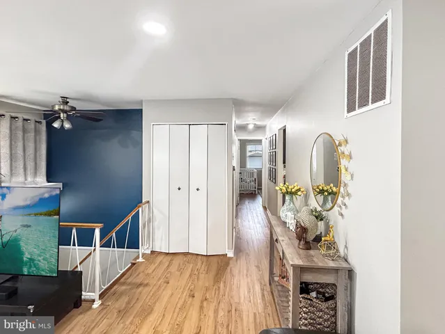 a view of a hallway with wooden floor and staircase