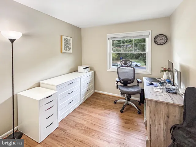 a view of a workspace with furniture and a window