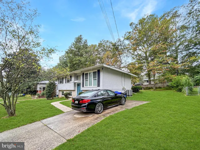 a car parked in front of a house with a yard