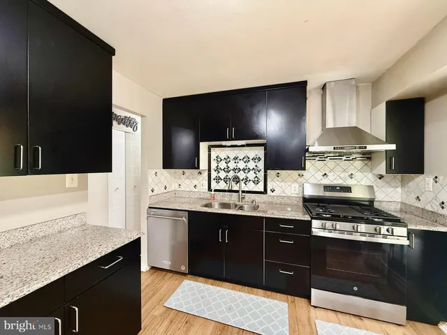 a kitchen with stainless steel appliances granite countertop a sink stove and cabinets