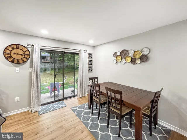 a view of a dining room with furniture wooden floor and a floor to ceiling window