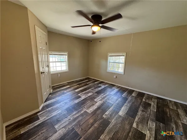 a view of an empty room and window and wooden floor