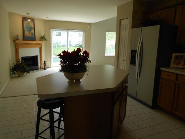 3040 Crystal Rock Road, Unit 3040 Naperville, IL 60564 - Photo 20 of 22 a kitchen with a table chairs and refrigerator