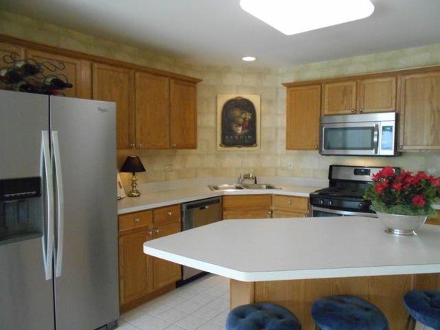 3040 Crystal Rock Road, Unit 3040 Naperville, IL 60564 - Photo 4 of 22 a kitchen with stainless steel appliances granite countertop a refrigerator sink and microwave