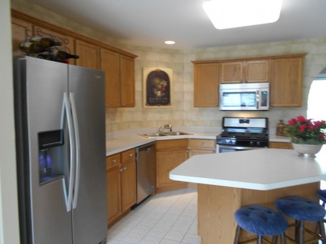 3040 Crystal Rock Road, Unit 3040 Naperville, IL 60564 - Photo 6 of 22 a kitchen with stainless steel appliances granite countertop a refrigerator sink and microwave