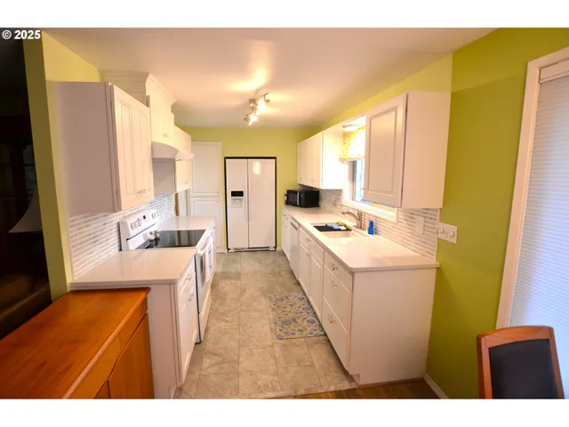 a view of a kitchen with a table and a chair