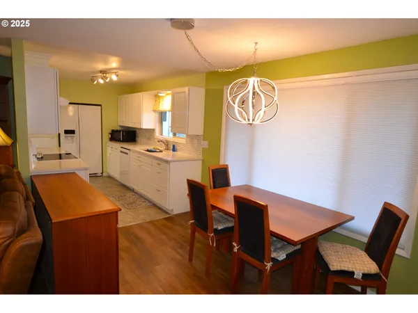 a kitchen with a dining table chairs and a refrigerator