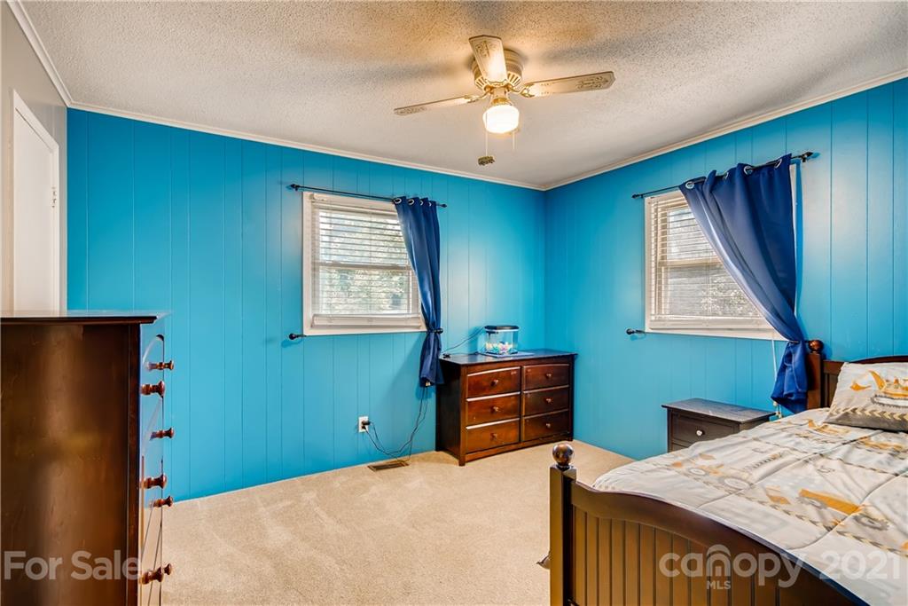 124 Riley Road Dallas, NC 28034 - Photo 7 of 9 a bedroom with a bed and a chandelier