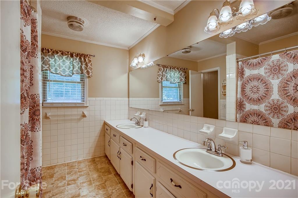 124 Riley Road Dallas, NC 28034 - Photo 9 of 9 a bathroom with a granite countertop double vanity sink a mirror and a shower