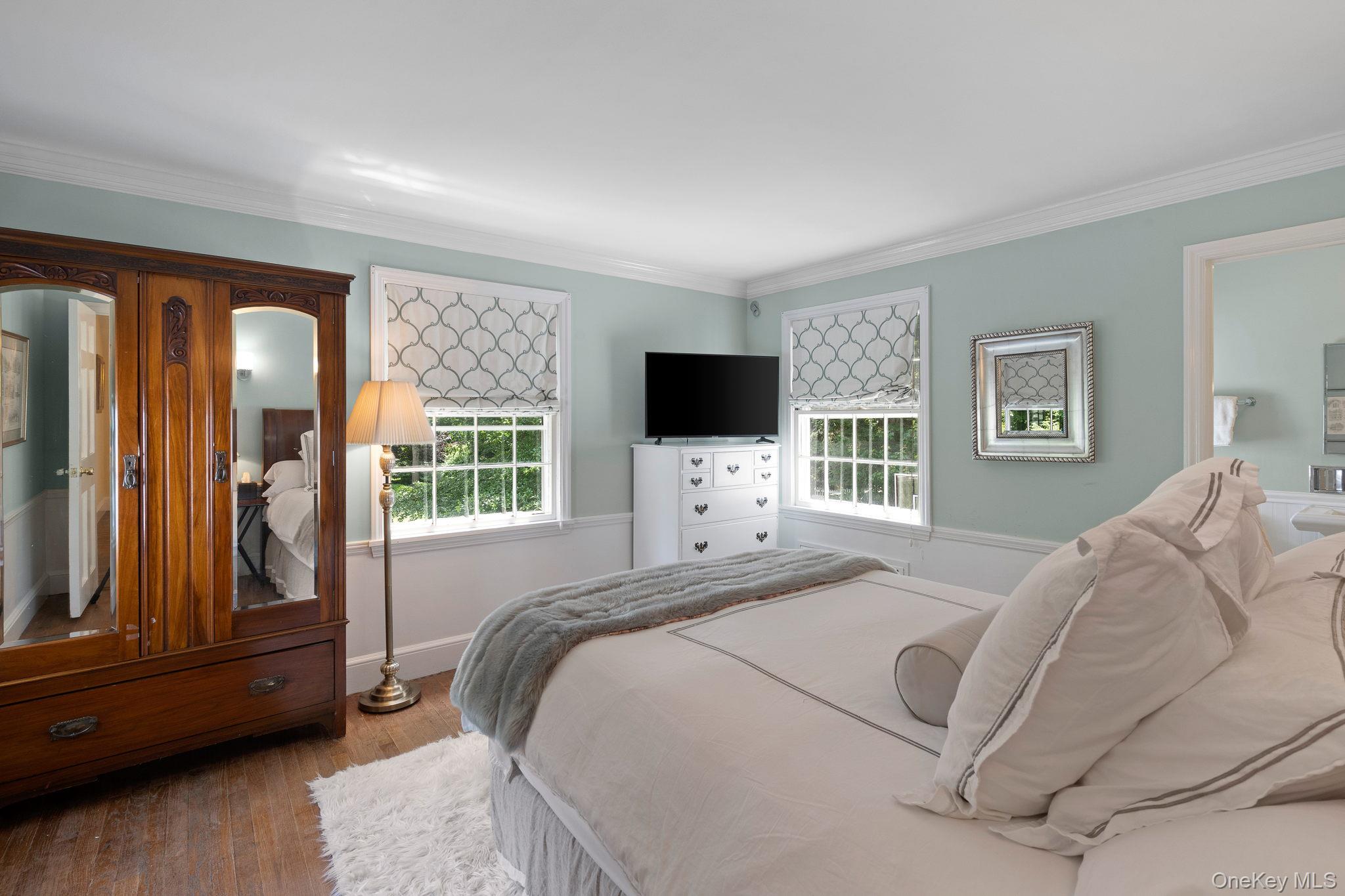 342 Woodbury Road Cold Spring Harbor, NY 11724 - Photo 20 of 29 a bedroom with a bed and tv with wooden floor