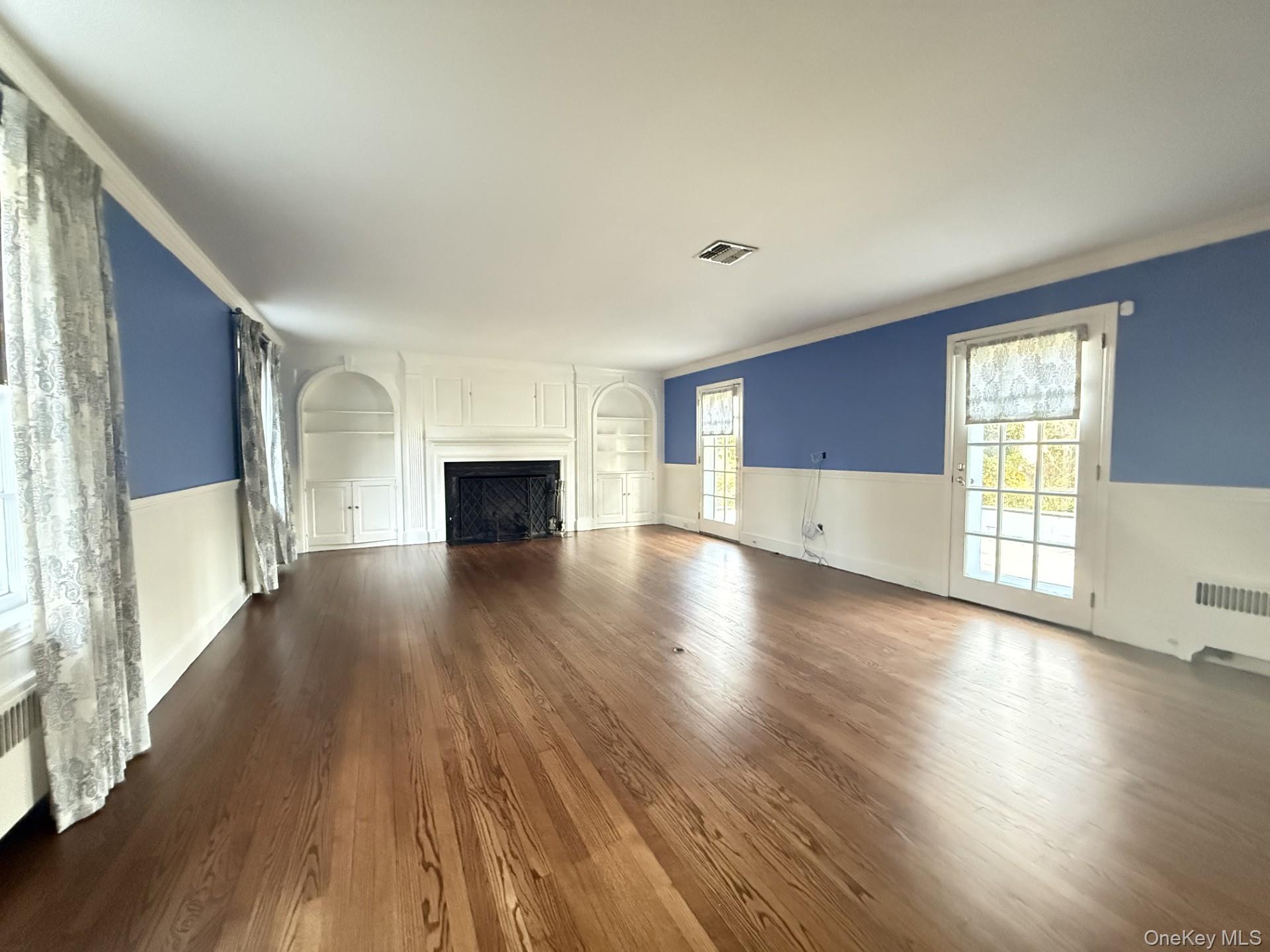 342 Woodbury Road Cold Spring Harbor, NY 11724 - Photo 6 of 29 an empty room with wooden floor and windows