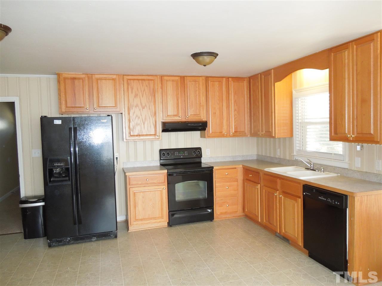 529 Maple Lane Raleigh, NC 27603 - Photo 6 of 21 a kitchen with stainless steel appliances granite countertop a refrigerator a sink dishwasher and wooden cabinets with a large window