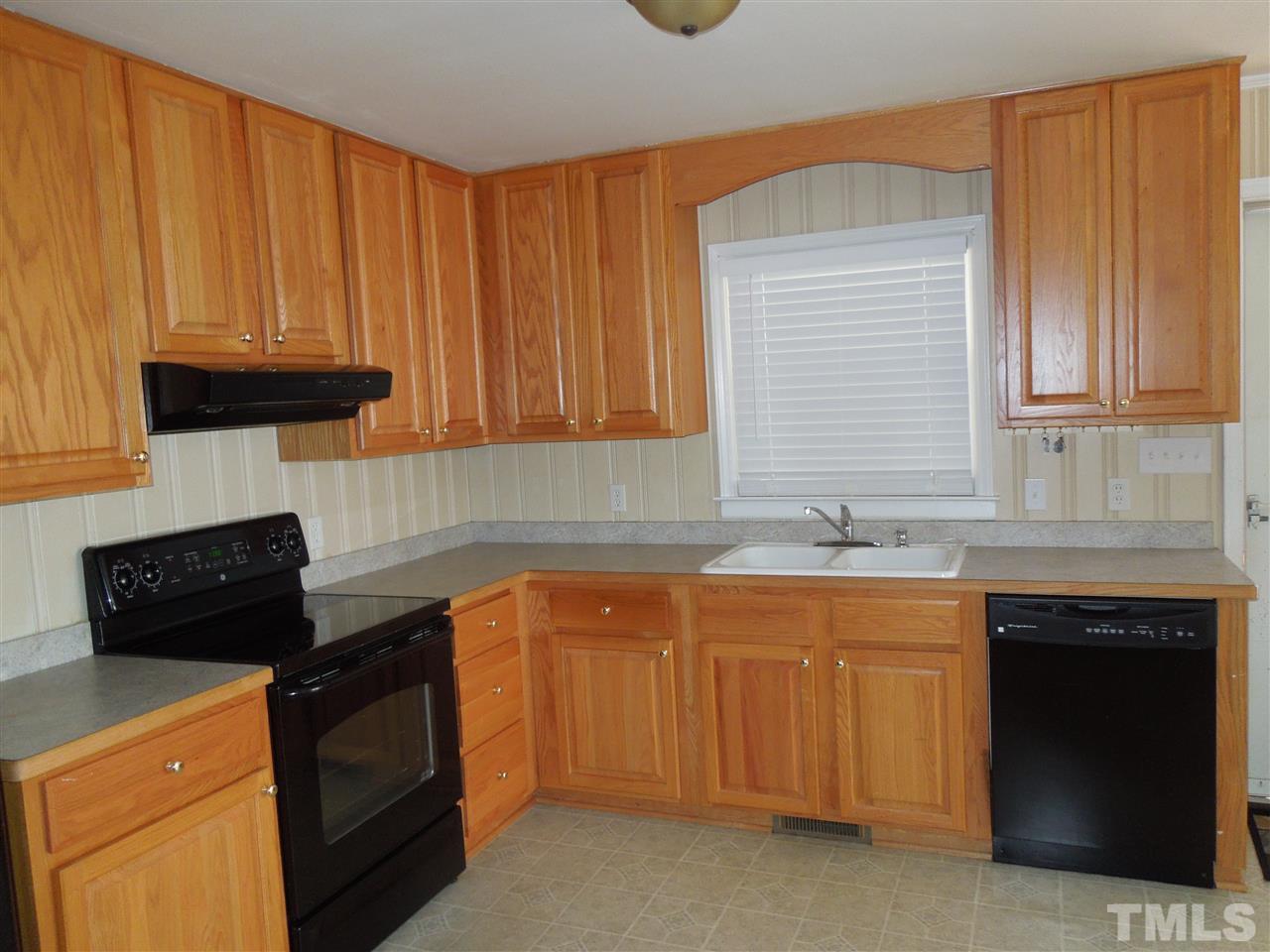 529 Maple Lane Raleigh, NC 27603 - Photo 7 of 21 a kitchen with granite countertop a sink dishwasher a stove and a microwave oven