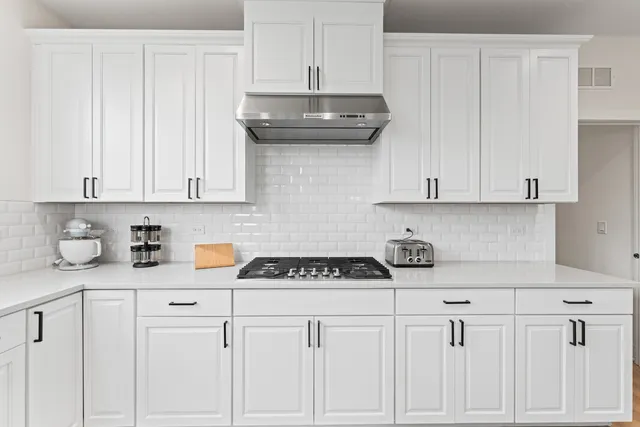 a kitchen with sink a stove and chairs
