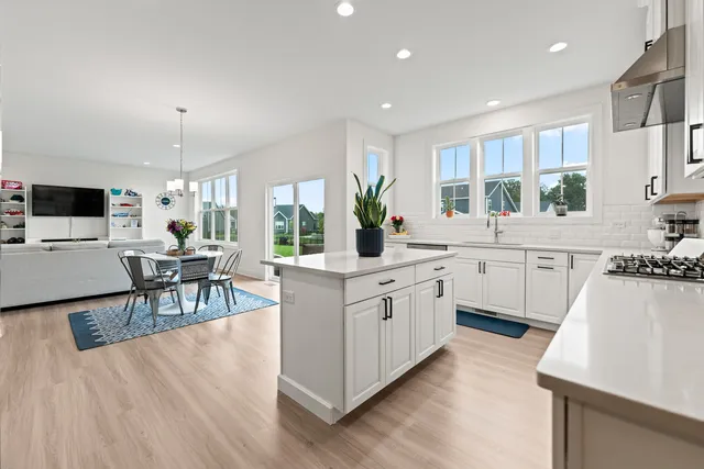 a kitchen with stainless steel appliances a refrigerator sink and wooden floor