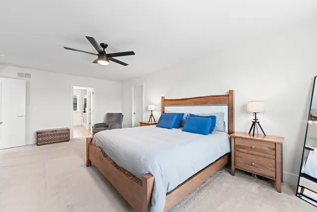 a bedroom with a bed a chandelier and a window