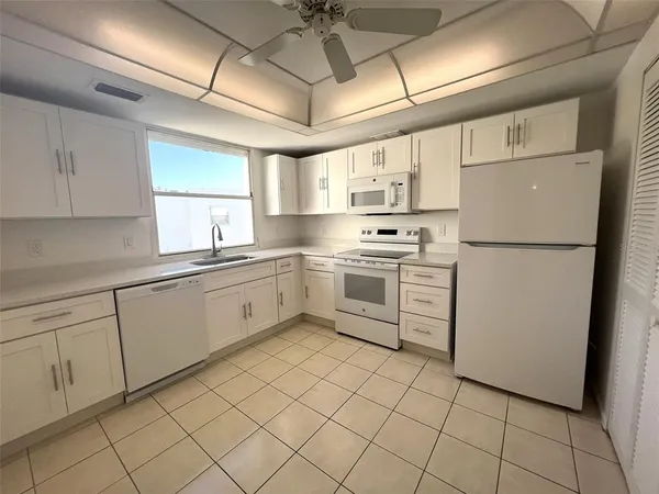 a kitchen with cabinets appliances a sink and a window