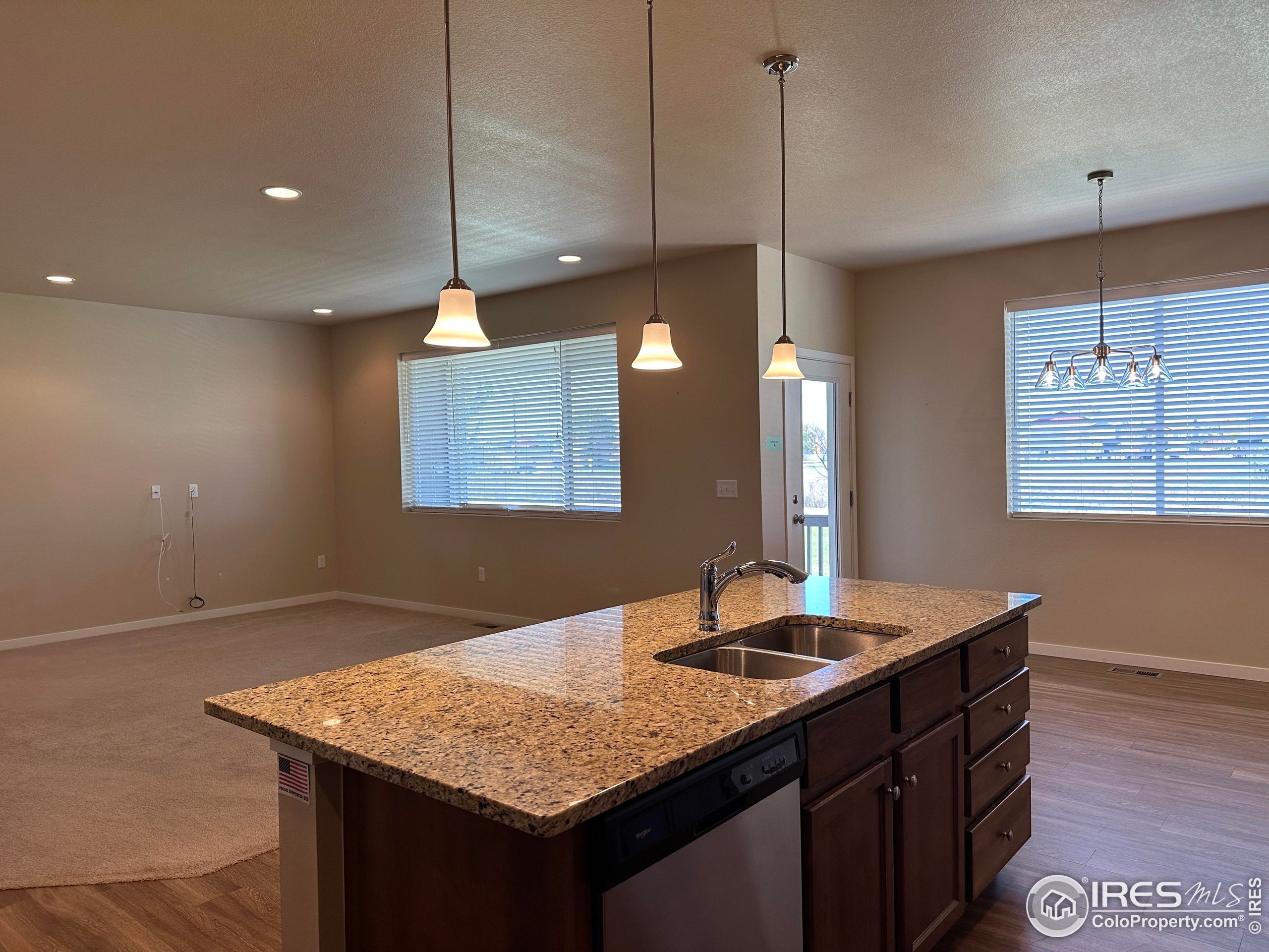 7213 Horsechestnut Street Wellington, CO 80549 - Photo 23 of 39 a kitchen with a sink chandelier and wooden floor