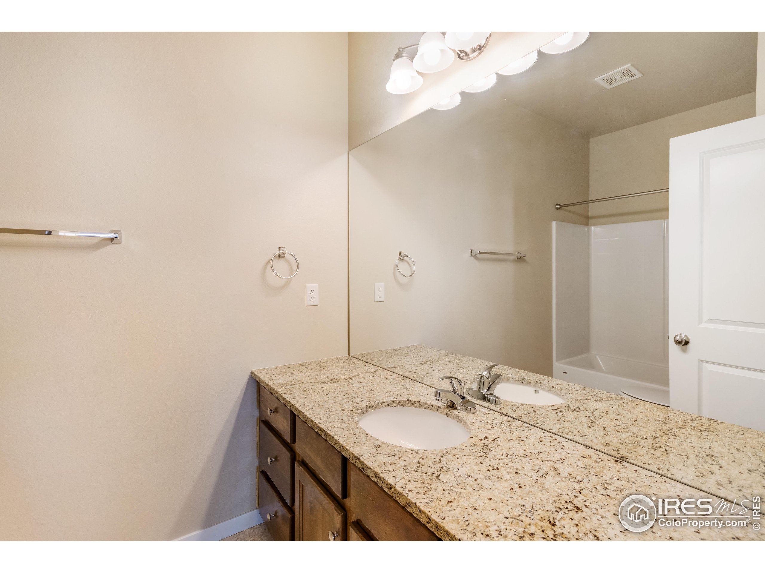 7213 Horsechestnut Street Wellington, CO 80549 - Photo 4 of 39 a bathroom with a granite countertop sink a mirror and a