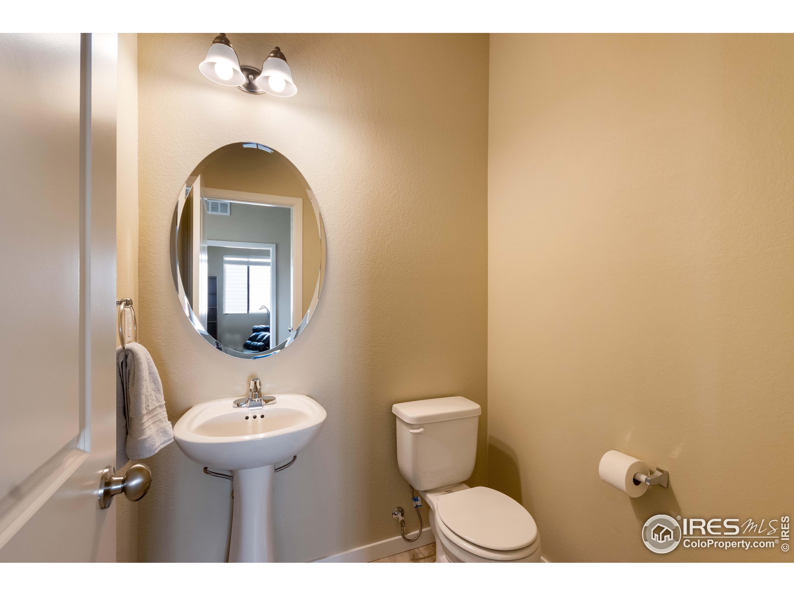 7213 Horsechestnut Street Wellington, CO 80549 - Photo 7 of 39 a bathroom with a toilet sink and mirror