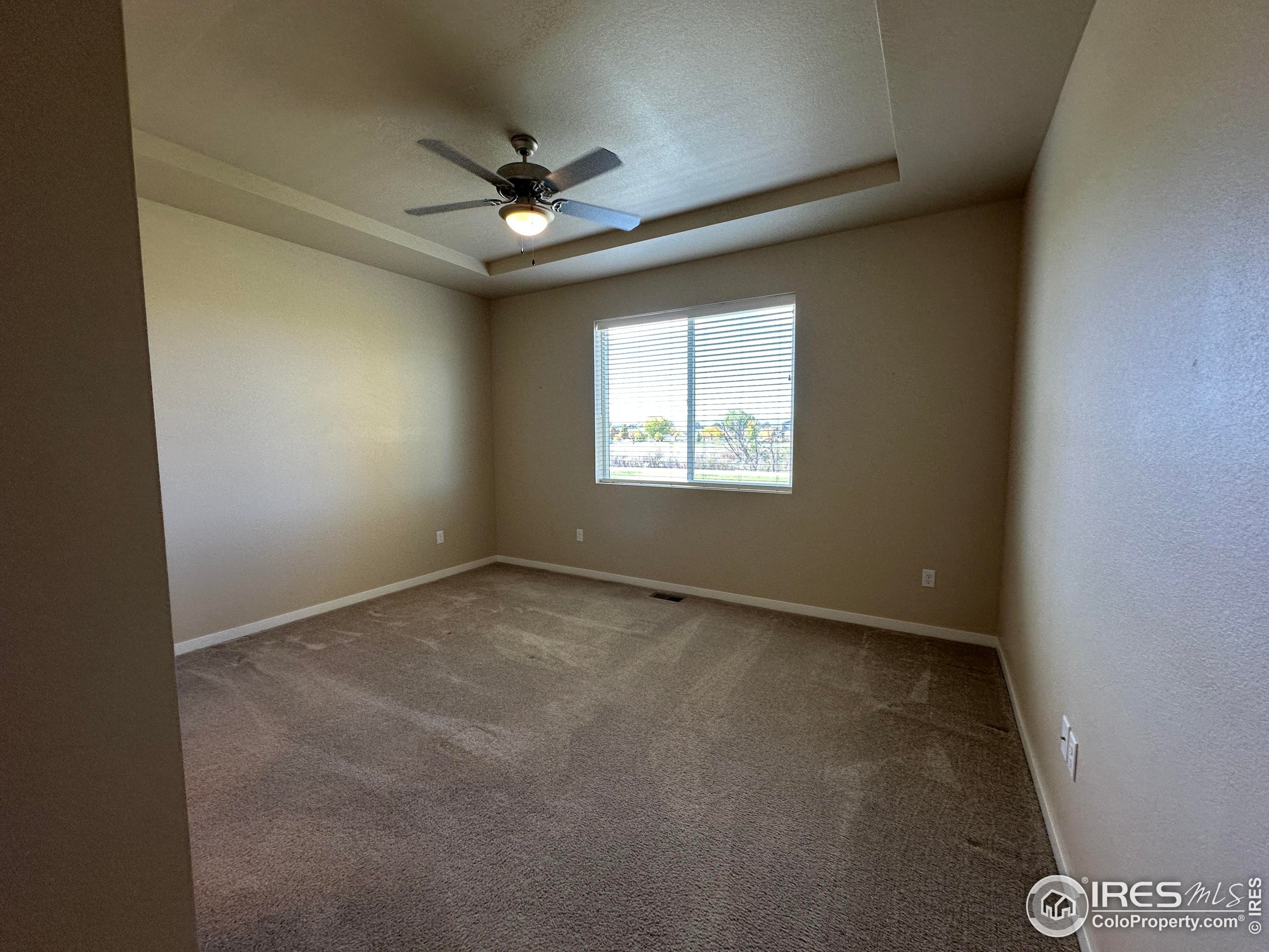7213 Horsechestnut Street Wellington, CO 80549 - Photo 9 of 39 an empty room with a window and a fan