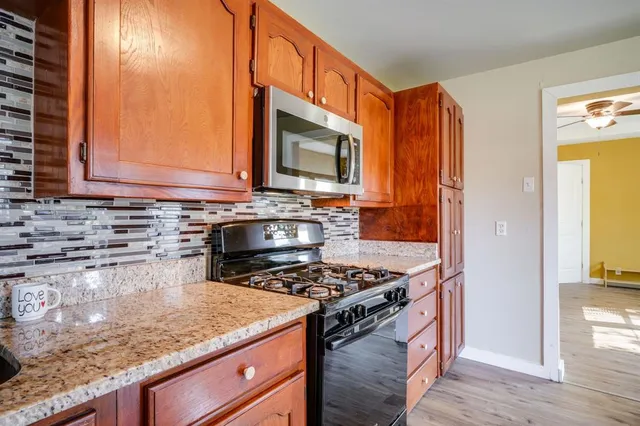 a kitchen with stainless steel appliances granite countertop a stove a sink and a microwave