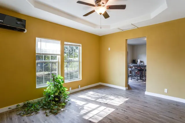 a view of a livingroom with a window and wooden floor