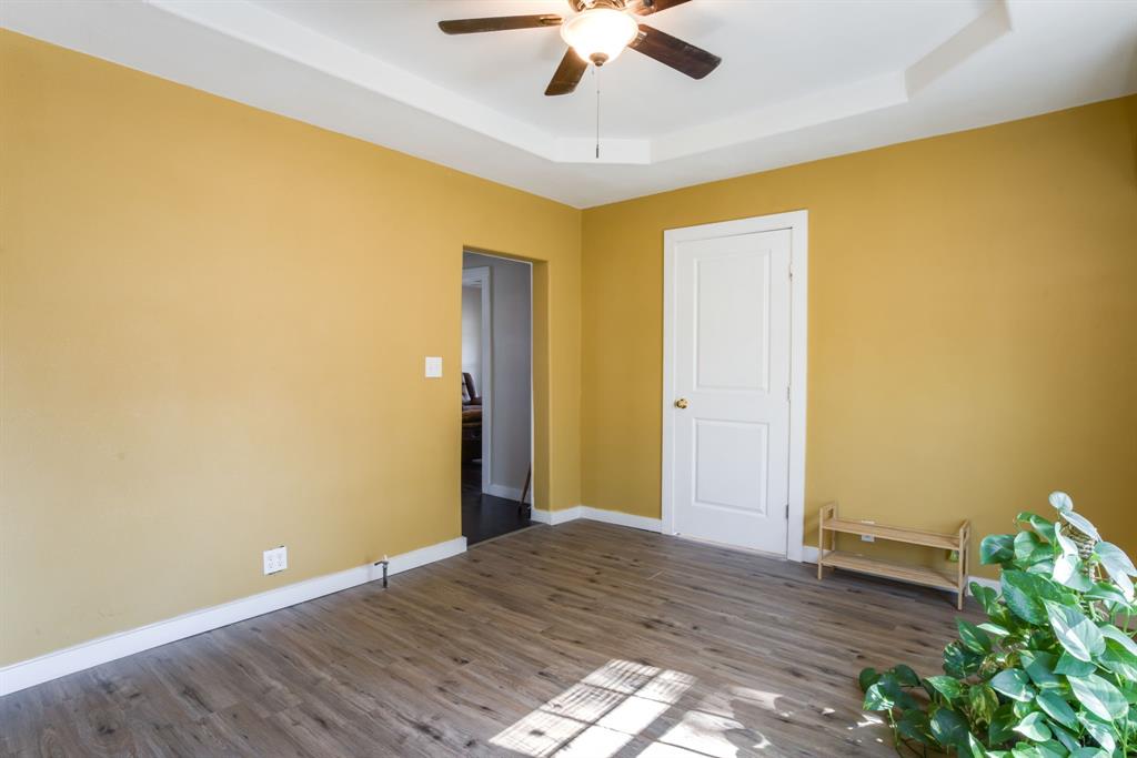 300 South Wall Street Itasca, TX 76055 - Photo 18 of 34 a view of a room with wooden floor and ceiling fan