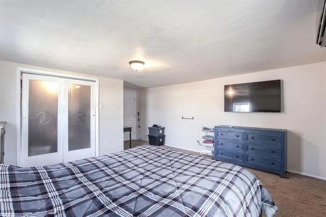a bedroom with a bed and a flat screen tv