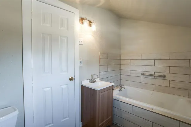 a bathroom with a tub a sink and a window