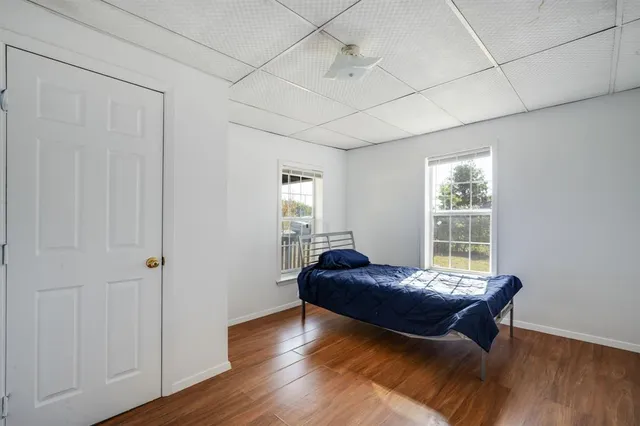 a bedroom with a bed and wooden floor