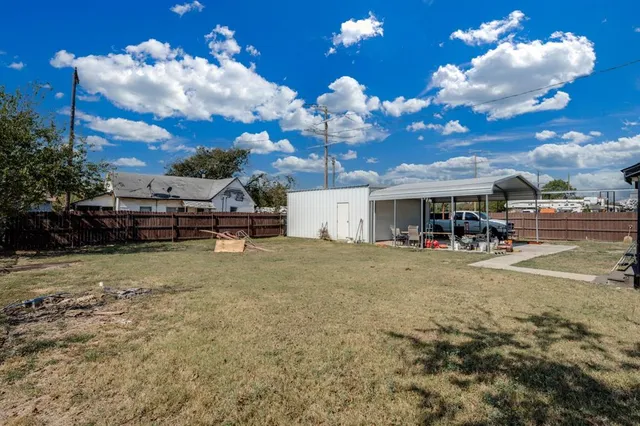 a group of people sitting in a yard in front of a house