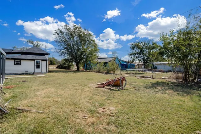a backyard of a house with table and chairs and a fire pit