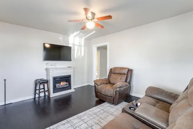 a living room with furniture a fireplace and a flat screen tv