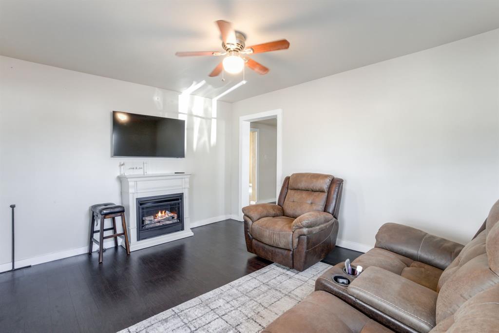 300 South Wall Street Itasca, TX 76055 - Photo 8 of 34 a living room with furniture a fireplace and a flat screen tv