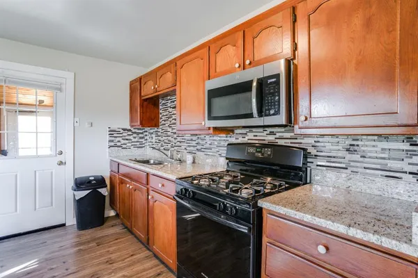 a kitchen with stainless steel appliances granite countertop a stove a sink and a microwave