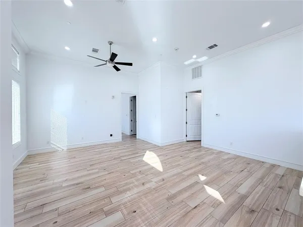 a view of a room with wooden floor and a ceiling fan