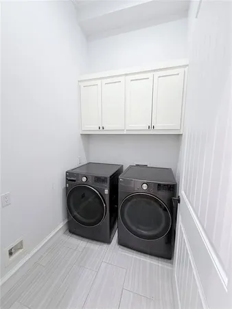 a utility room with washing machine and a view of bedroom