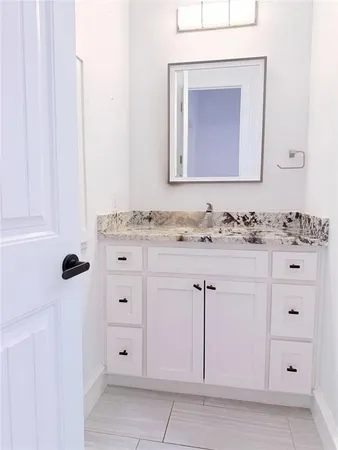 a bathroom with a sink vanity and mirror